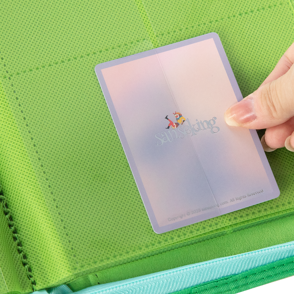 Sanseking AXIS-SK Light Green 12-pocket trading card binder card being loaded into a pocket