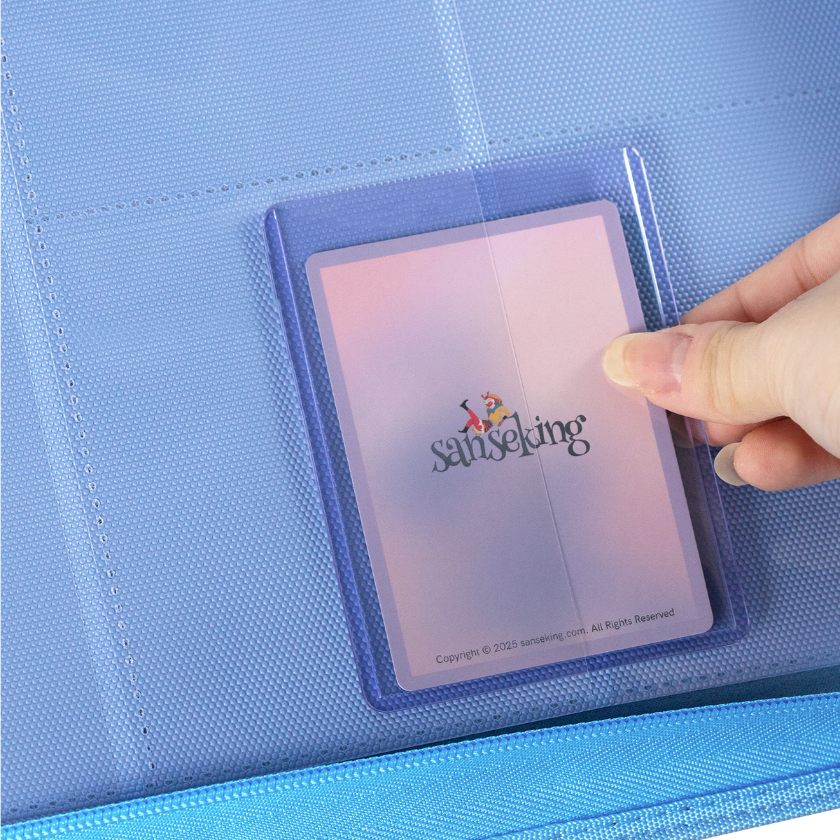 Sanseking PORT Blue 9-pocket toploader binder protected trading card being inserted into a page pocket