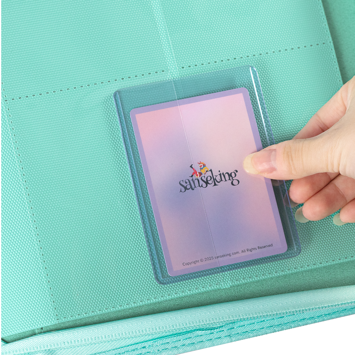 Sanseking PORT Green 9-pocket toploader binder protected trading card being inserted into a page pocket